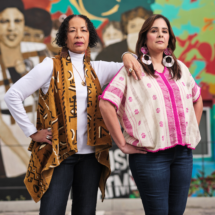 Picture of two women in front of a mural